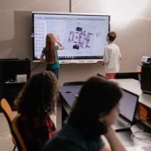Kids learning with an interactive board in a modern classroom setting.